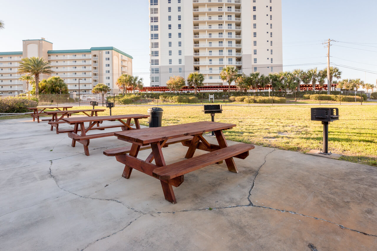 picnic tables charcoal grills and a grassy area to play games at Grand Caribbean condos in Perdido Key